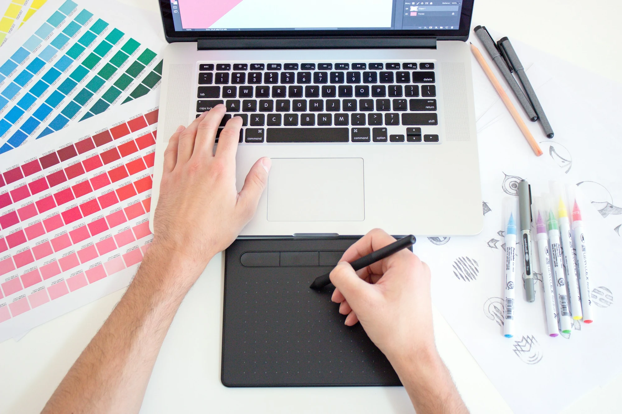 A designer working with colour swatches and a pen tablet