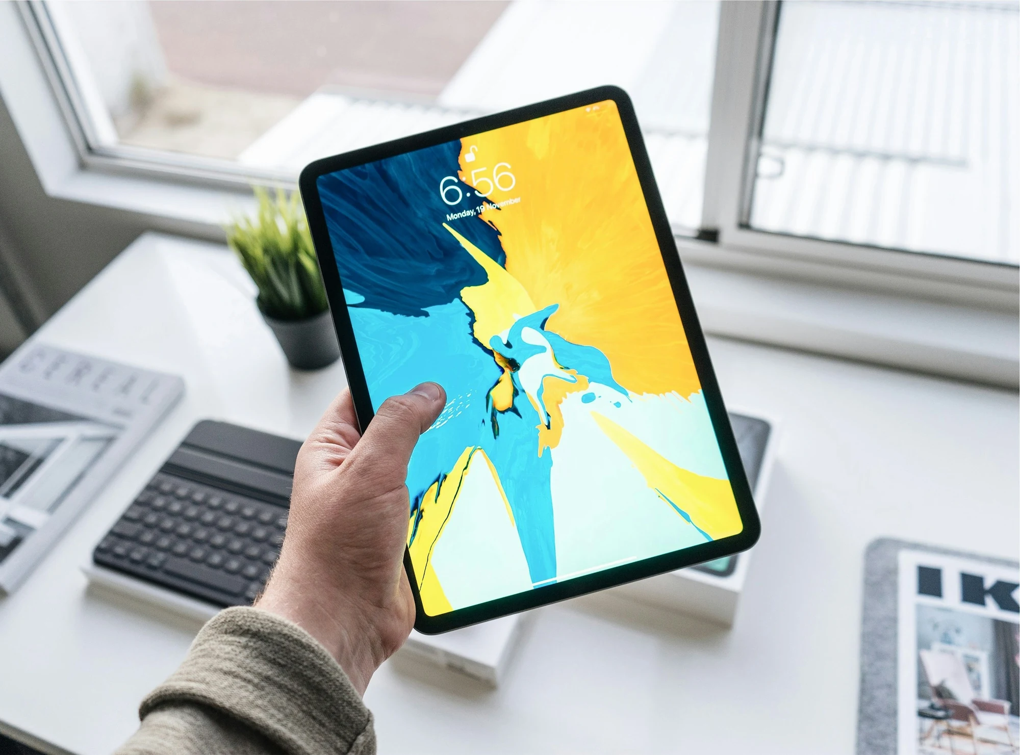 A hand holding a tablet
