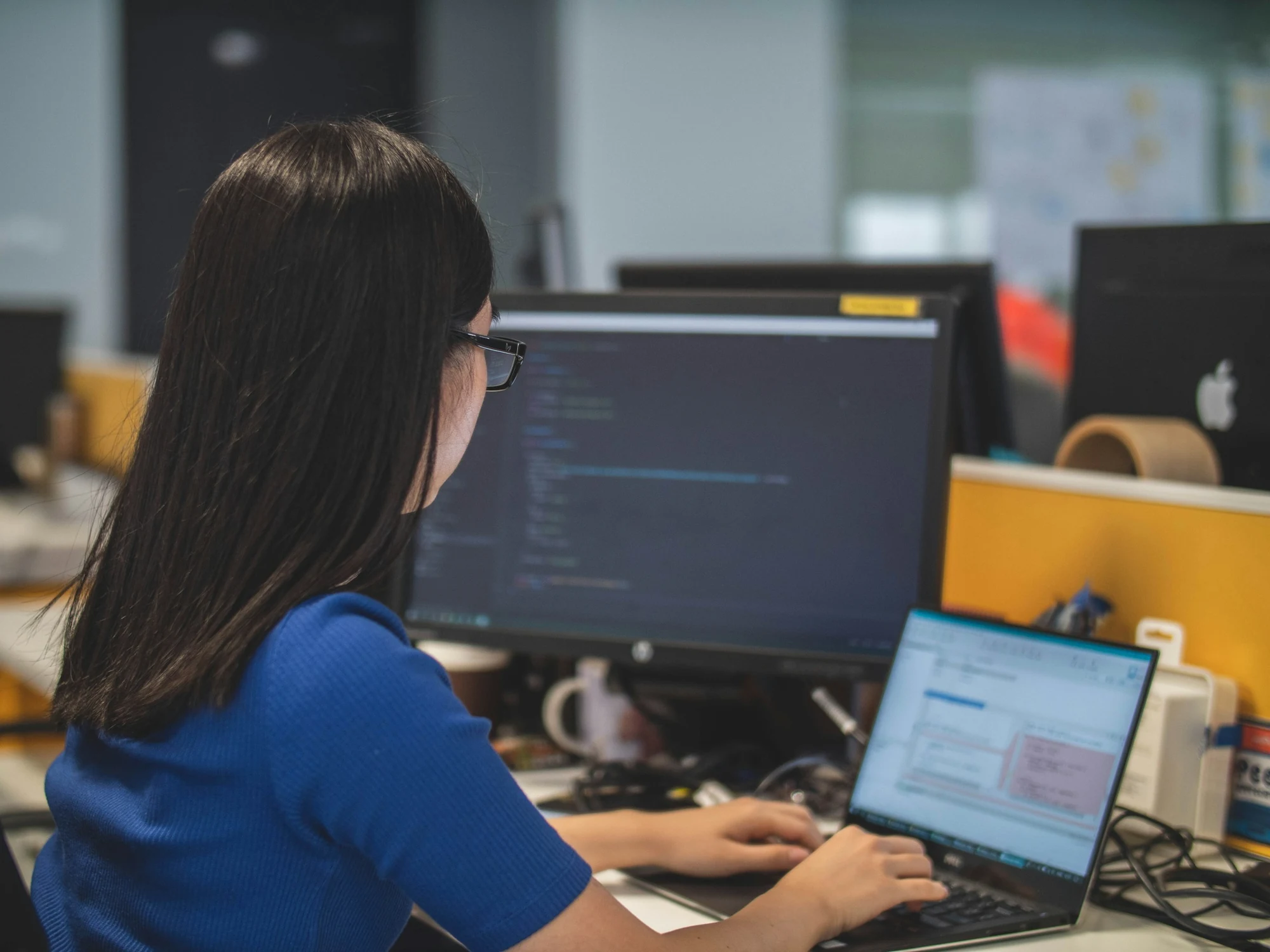 A software developer writing code at her desk